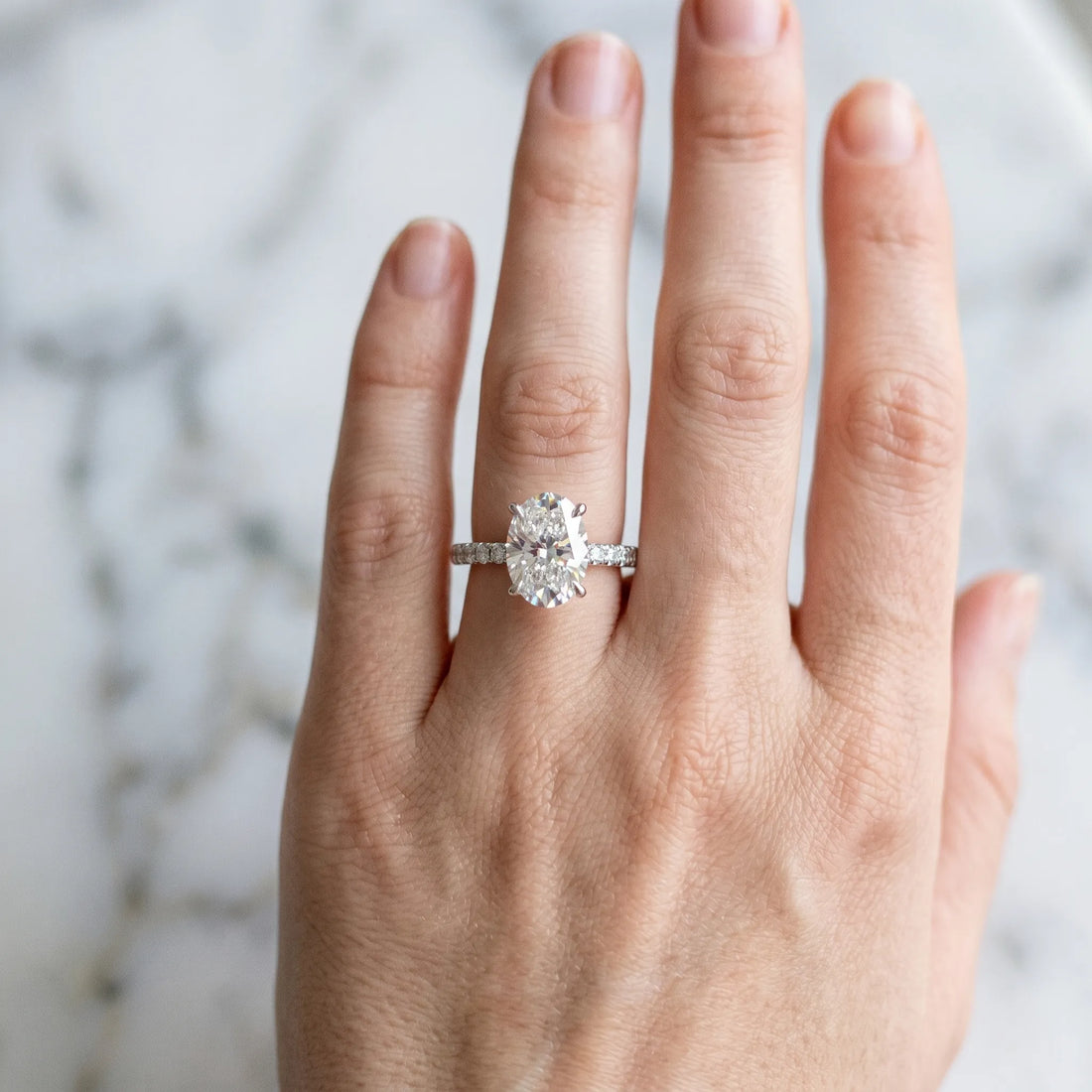 Platinum Oval Cut Diamond Brilliant Solitaire Ring with Pavé Band and Four-Prong Setting