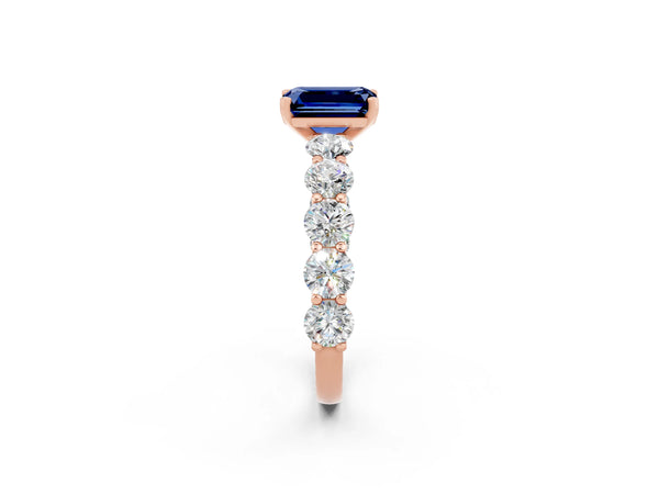 Rose gold Emerald Cut Blue Sapphire Prong Setting with Side Stones on a Pave Band