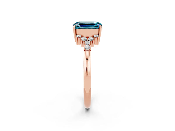 Rose gold Emerald Cut Blue Topaz Ring with Side Stones and Four-Prong Setting