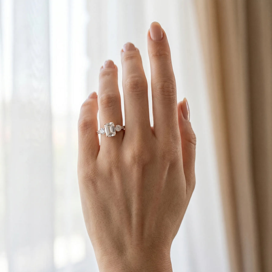Rose gold Emerald Cut Diamond Three-Stone Ring with Round Side Stones and Pavé Band