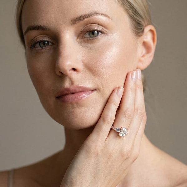 Rose gold Emerald Cut Diamond Three-Stone Ring with Round Side Stones and Pavé Band