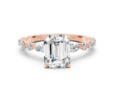 Rose gold Emerald Cut Moissanite Solitaire with Side Stones on a Pavé Band and Four-Prong Setting