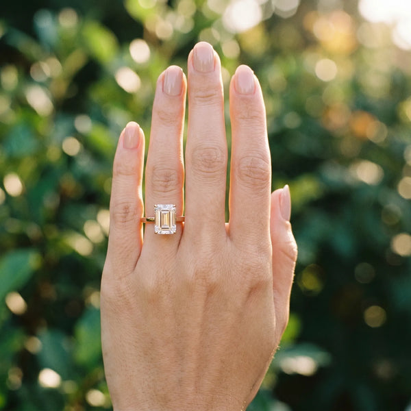 Rose gold Emerald Cut Solitaire Engagement Ring with Four-Prong Setting on a Classic Band