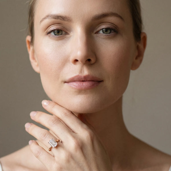 Rose gold Emerald Cut Solitaire Engagement Ring with Four-Prong Setting on a Classic Band