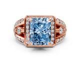 Rose gold Fancy Blue Radiant Cut Diamond Halo Ring with Split Shank and Bezel Accents and Four-Prong Setting