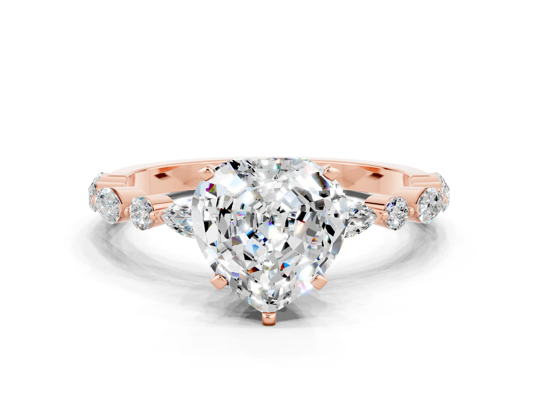Rose gold Heart Cut Moissanite Solitaire with Side Stones on a Pavé Band and Four-Prong Setting