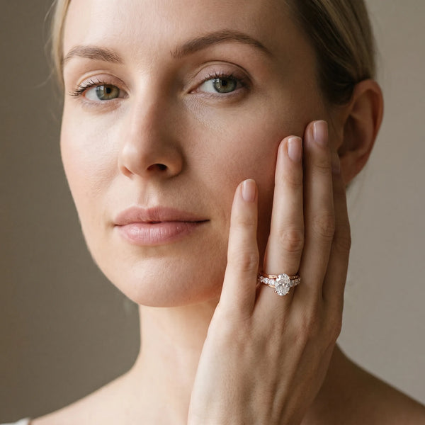 Rose gold Oval Brilliant Solitaire with Side Stones on a Pave Band and Four-Prong Setting