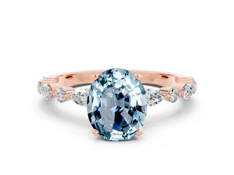 Rose gold Oval Cut Aquamarine Solitaire with Side Stones on a Pavé Band and Four-Prong Setting