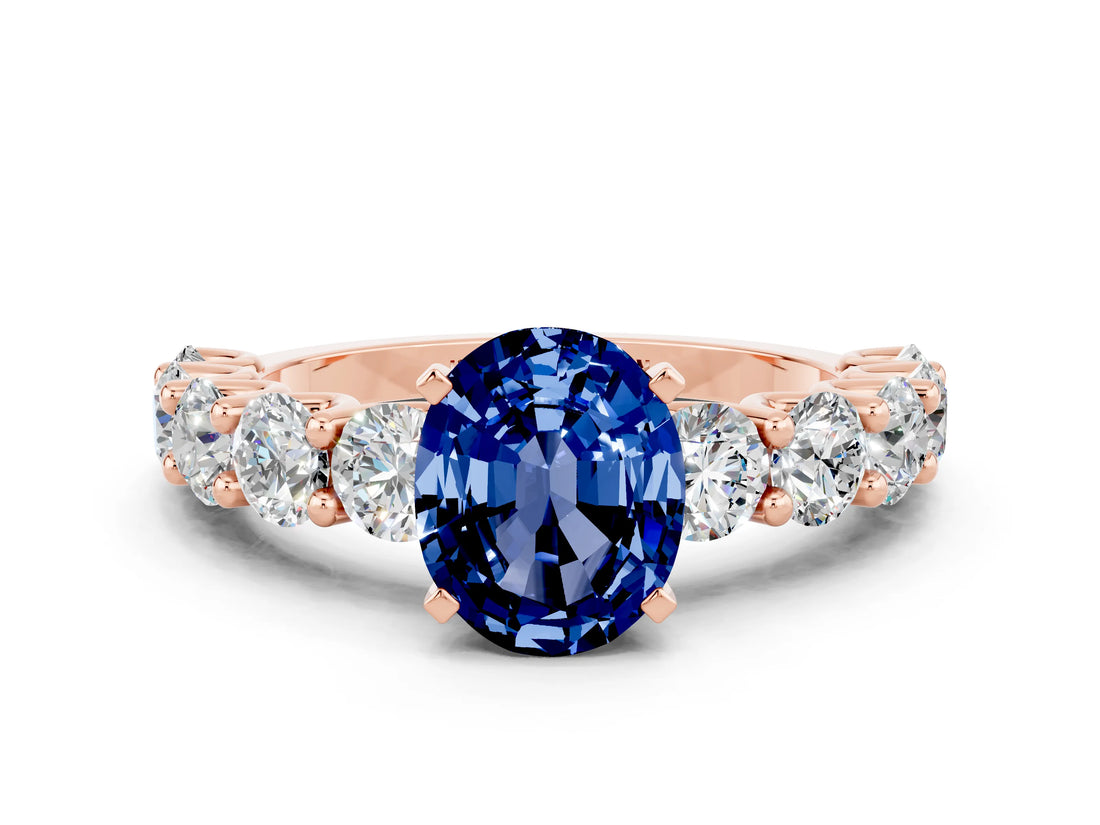 Rose gold Oval Cut Blue Sapphire Prong Setting with Side Stones on a Pave Band