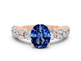 Rose gold Oval Cut Blue Sapphire Prong Setting with Side Stones on a Pave Band