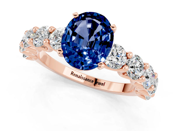 Rose gold Oval Cut Blue Sapphire Prong Setting with Side Stones on a Pave Band