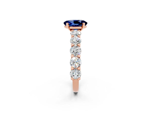 Rose gold Oval Cut Blue Sapphire Prong Setting with Side Stones on a Pave Band