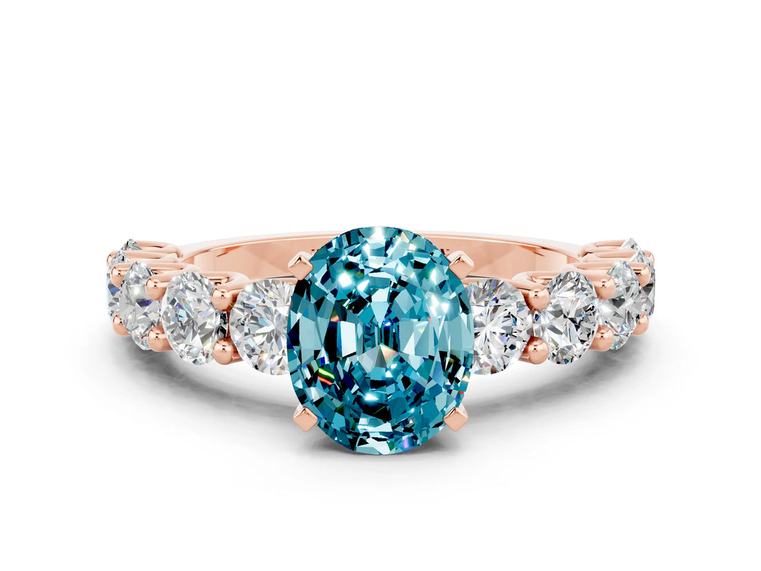 Rose gold Oval Cut Blue Topaz Prong Setting with Side Stones on a Pave Band