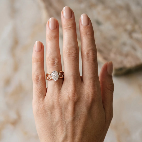 Rose gold Oval Cut Solitaire Diamond with Side Stones on Criss-Cross Band and Four-Prong Setting