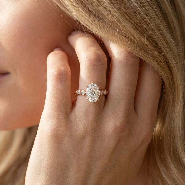 Rose gold Oval Solitaire Bezel Accent Diamond Engagement Ring with Beaded Band and Four-Prong Setting