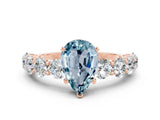 Rose gold Pear Cut Aquamarine Prong Setting with Side Stones on a Pave Band