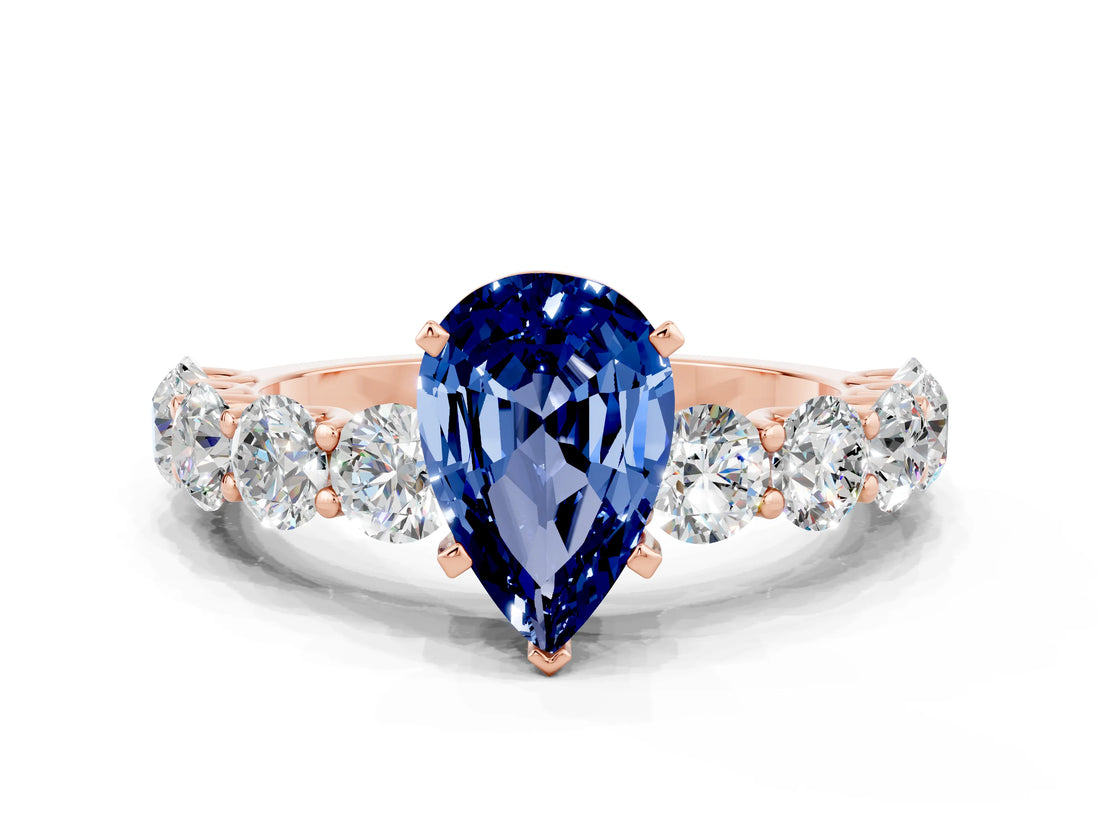 Rose gold Pear Cut Blue Sapphire Prong Setting with Side Stones on a Pave Band
