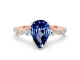 Rose gold Pear Cut Blue Sapphire Solitaire with Side Stones on a Pavé Band and Four-Prong Setting