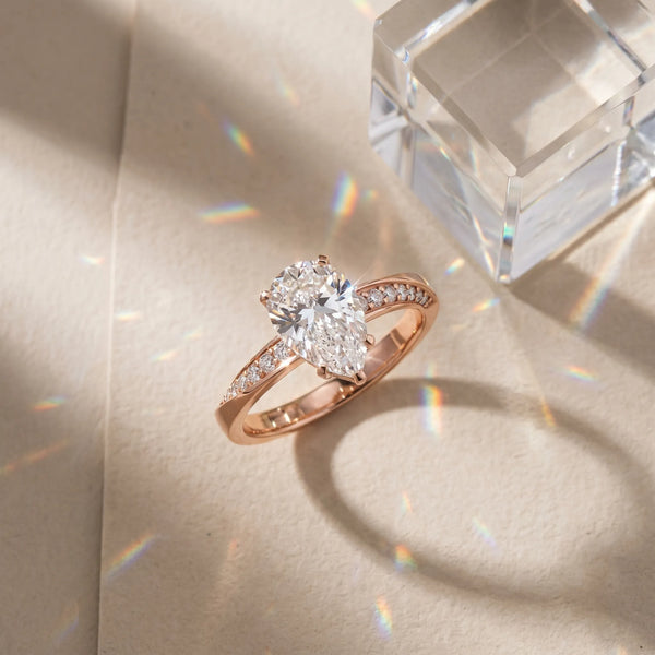 Rose gold Pear Cut Diamond Engagement Ring with Side Stone Accents and Four-Prong Setting