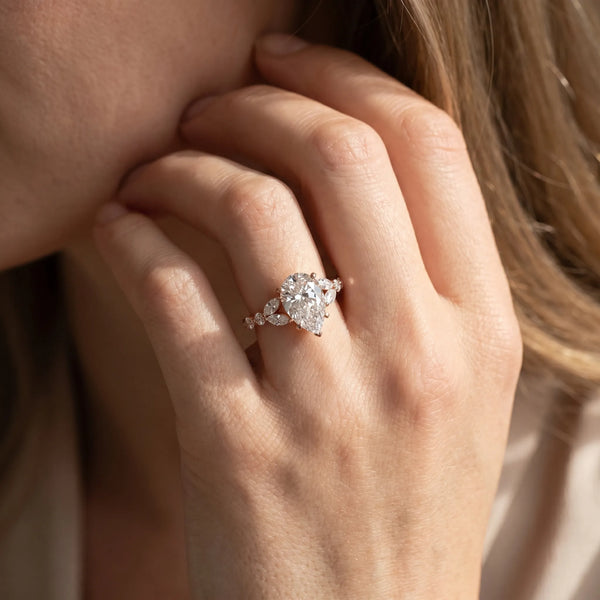 Rose gold Pear Cut Diamond Solitaire Ring with Side Stones and Four-Prong Setting