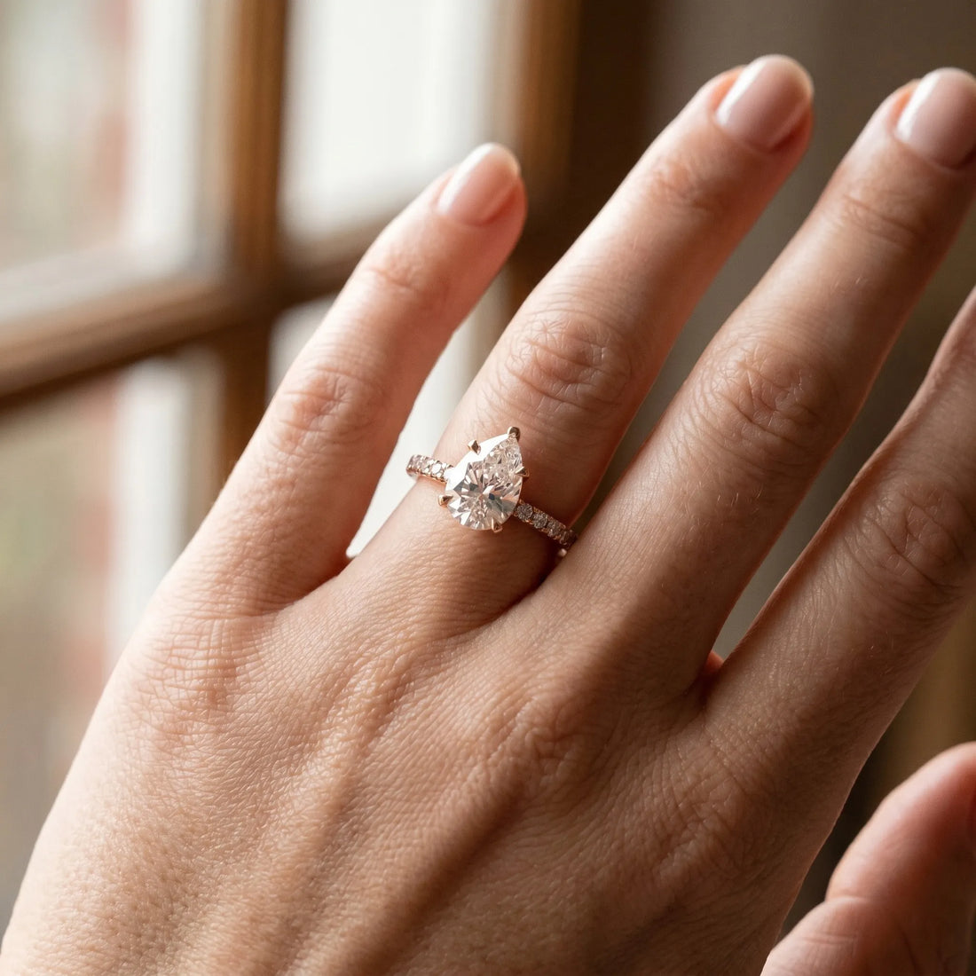 Rose gold Pear Cut Moissanite Solitaire Ring with Round  Pavé Band and Four-Prong Setting