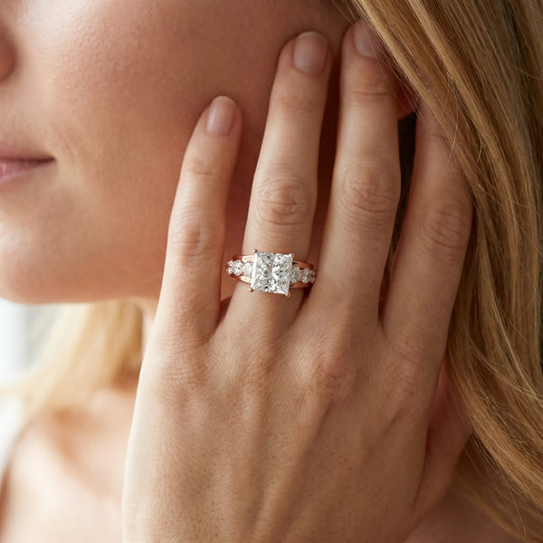 Rose gold Princess Brilliant Solitaire with Side Stones on a Pave Band and Four-Prong Setting