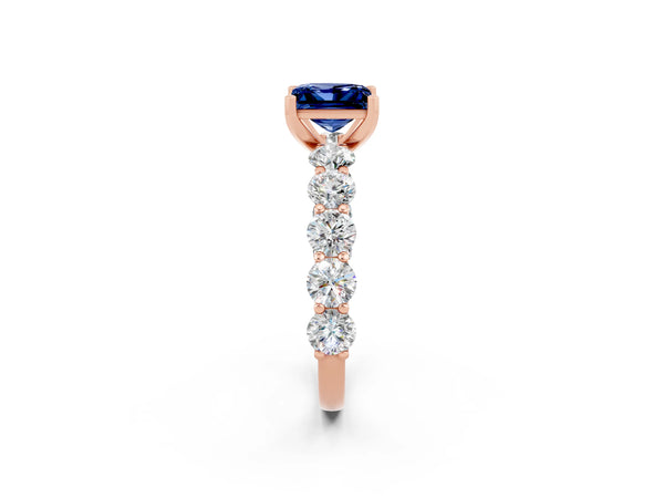 Rose gold Princess Cut Blue Sapphire Prong Setting with Side Stones on a Pave Band