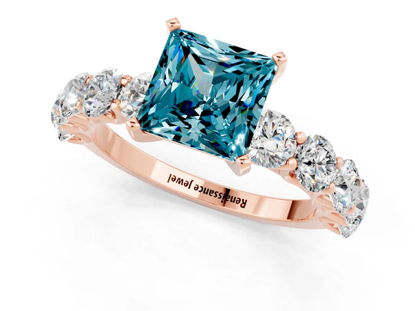 Rose gold Princess Cut Blue Topaz Prong Setting with Side Stones on a Pave Band