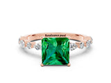 Rose gold Princess Cut Emerald Solitaire with Side Stones on a Pavé Band and Four-Prong Setting