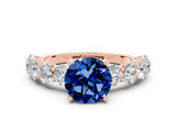 Rose gold Round Cut Blue Sapphire Prong Setting with Side Stones on a Pave Band