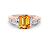 Rose gold Three-Stone Emerald Cut Cut Diamond Ring with Trillion Side Stones and Four-Prong Setting