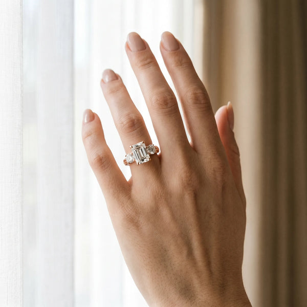 Rose gold Three-Stone Emerald Cut Diamond Ring with Channel-Set Band and Prong Setting