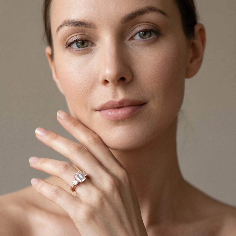 Rose gold Three-Stone Emerald Cut Diamond Ring with Channel-Set Band and Prong Setting