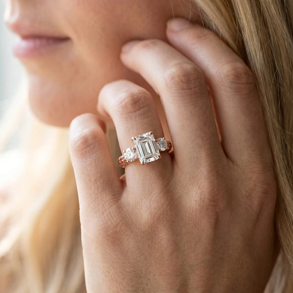 Rose gold Three-Stone Emerald Cut Diamond Ring with Channel-Set Band and Prong Setting