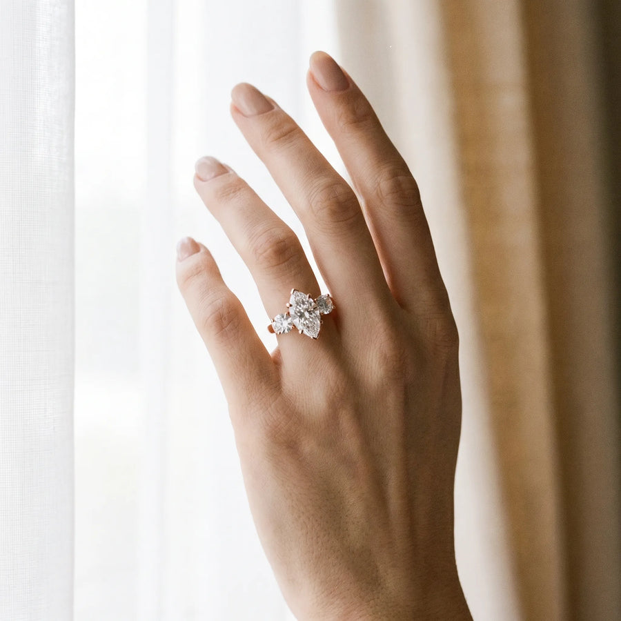 Rose gold Three-Stone Marquise Cut Diamond Ring with Round Accent Stones, Prong Setting, and Classic Band