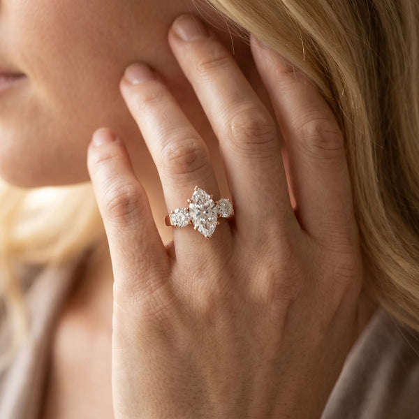 Rose gold Three-Stone Marquise Cut Diamond Ring with Round Accent Stones, Prong Setting, and Classic Band