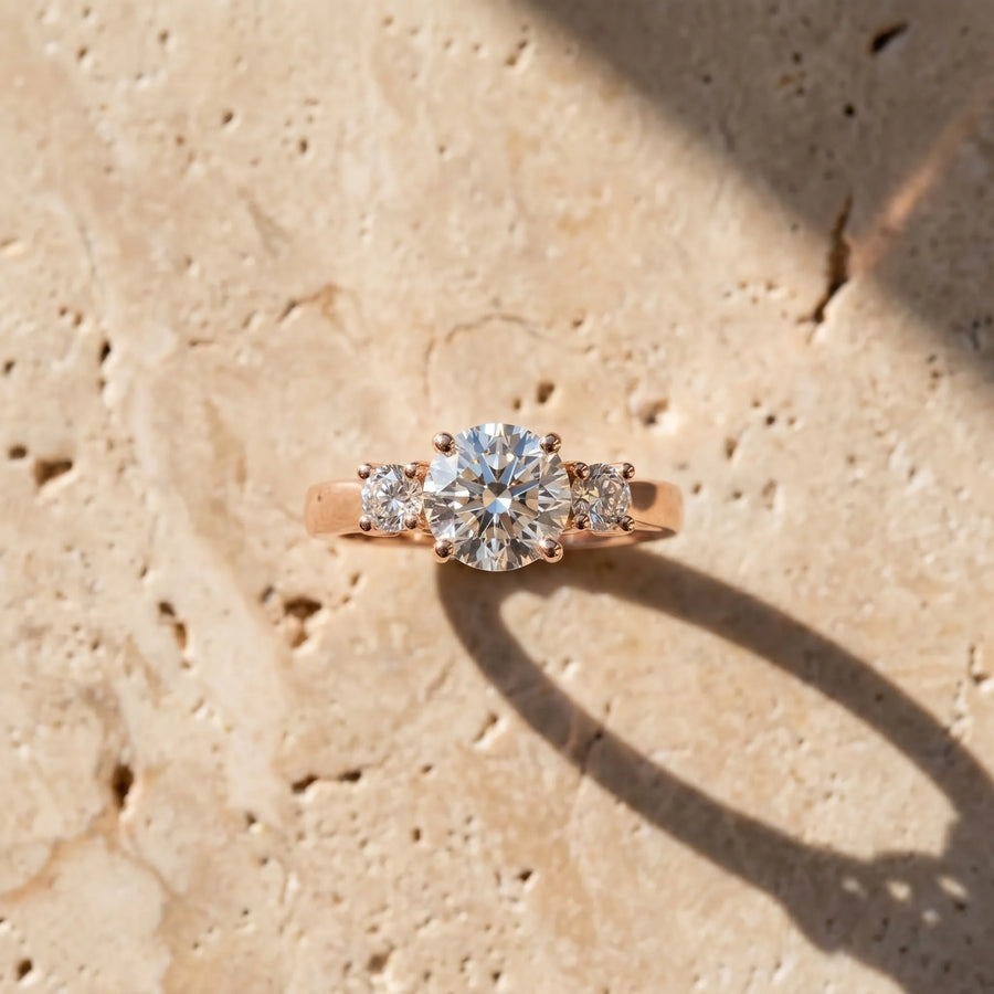 Rose gold Three-Stone Marquise Diamond Solitaire with Round Accents and Prong Setting on a Classic Band