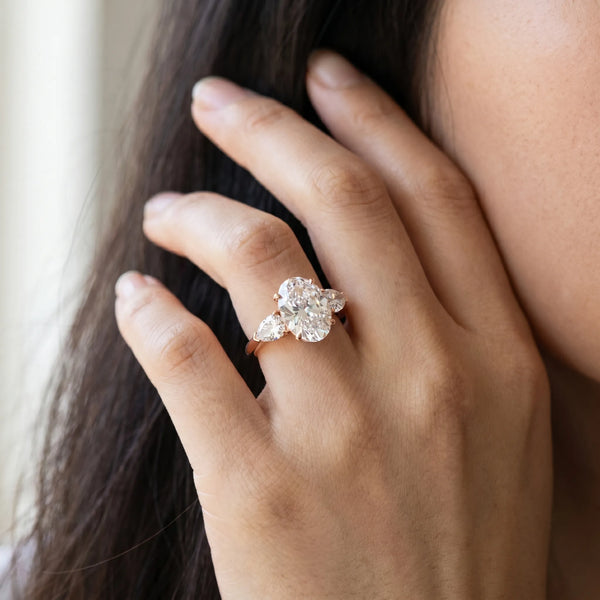 Rose gold Three-Stone Oval Cut Diamond Ring with Pear Side Stones and Four-Prong Setting