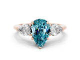 Rose gold Three-Stone Pear Cut Blue Topaz Ring with Pear Side Stones and Four-Prong Setting
