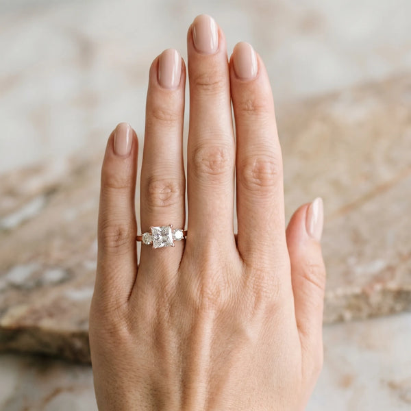 Rose gold Three-Stone Princess Cut Diamond Ring with Round Accent Stones, Prong Setting, and Classic Band