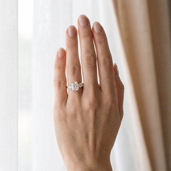 Rose gold Three-Stone Radiant Cut Diamond Ring with Round Accent Stones, Prong Setting, and Classic Band