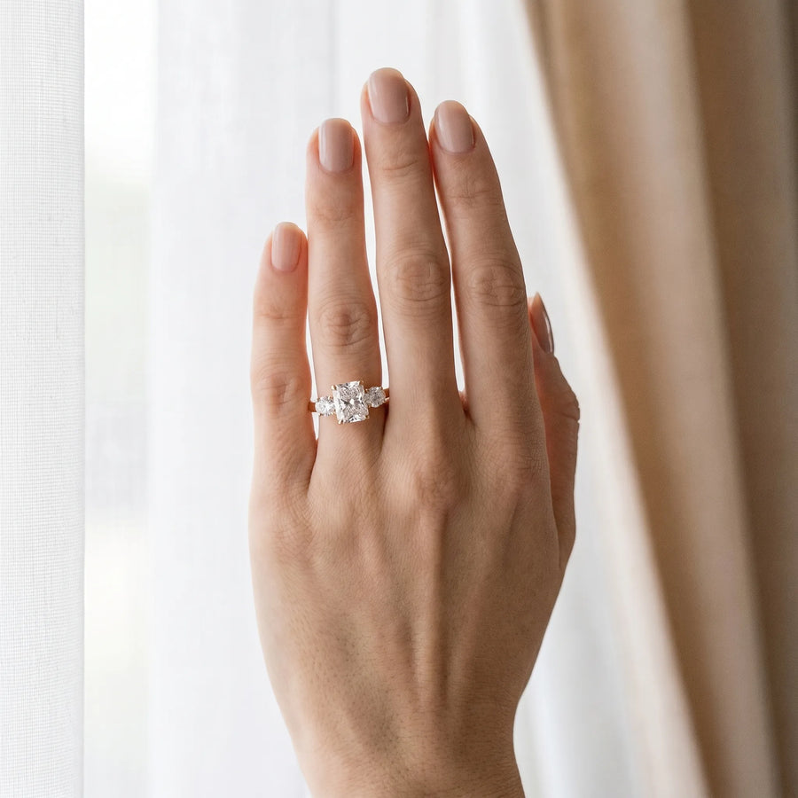 Rose gold Three-Stone Radiant Cut Diamond Ring with Round Accent Stones, Prong Setting, and Classic Band