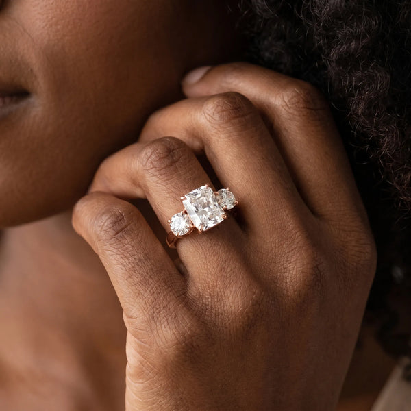 Rose gold Three-Stone Radiant Cut Diamond Ring with Round Accent Stones, Prong Setting, and Classic Band