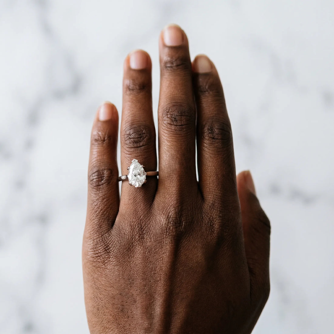 Silver Pear Cut Diamond Solitaire Ring with Flower Prong Setting and Classic Band
