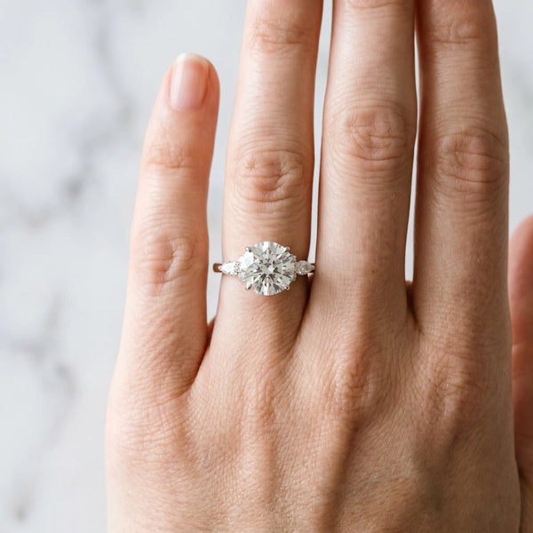White gold Round Brilliant Diamond Solitaire Ring with Pear Side Stones and Four-Prong Setting