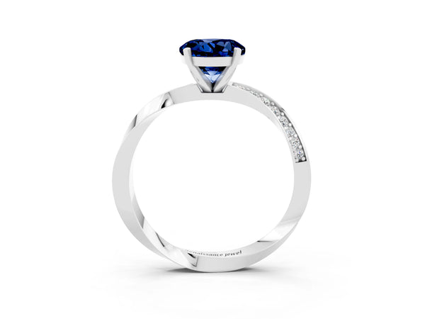 Silver Round Cut Blue Sapphire Engagement Ring with Side Stone Accents and Four-Prong Setting