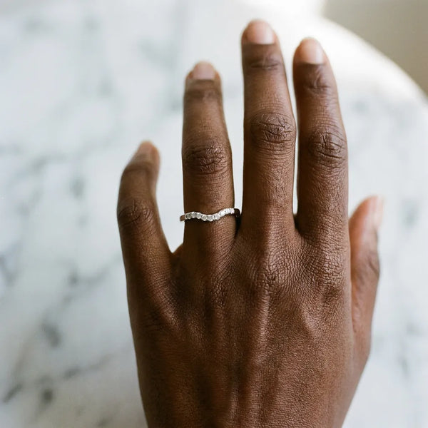 Silver Curved Diamond Wedding Band with Round Cut Stones and Shared Prong Setting