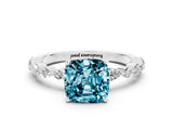 White gold Cushion Cut Blue Topaz Solitaire with Side Stones on a Pavé Band and Four-Prong Setting