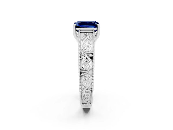 White gold Emerald Cut Blue Sapphire Solitaire Ring with Engraved Band and Four-Prong Setting