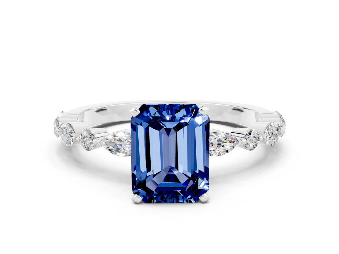 White gold Emerald Cut Blue Sapphire Solitaire with Side Stones on a Pavé Band and Four-Prong Setting
